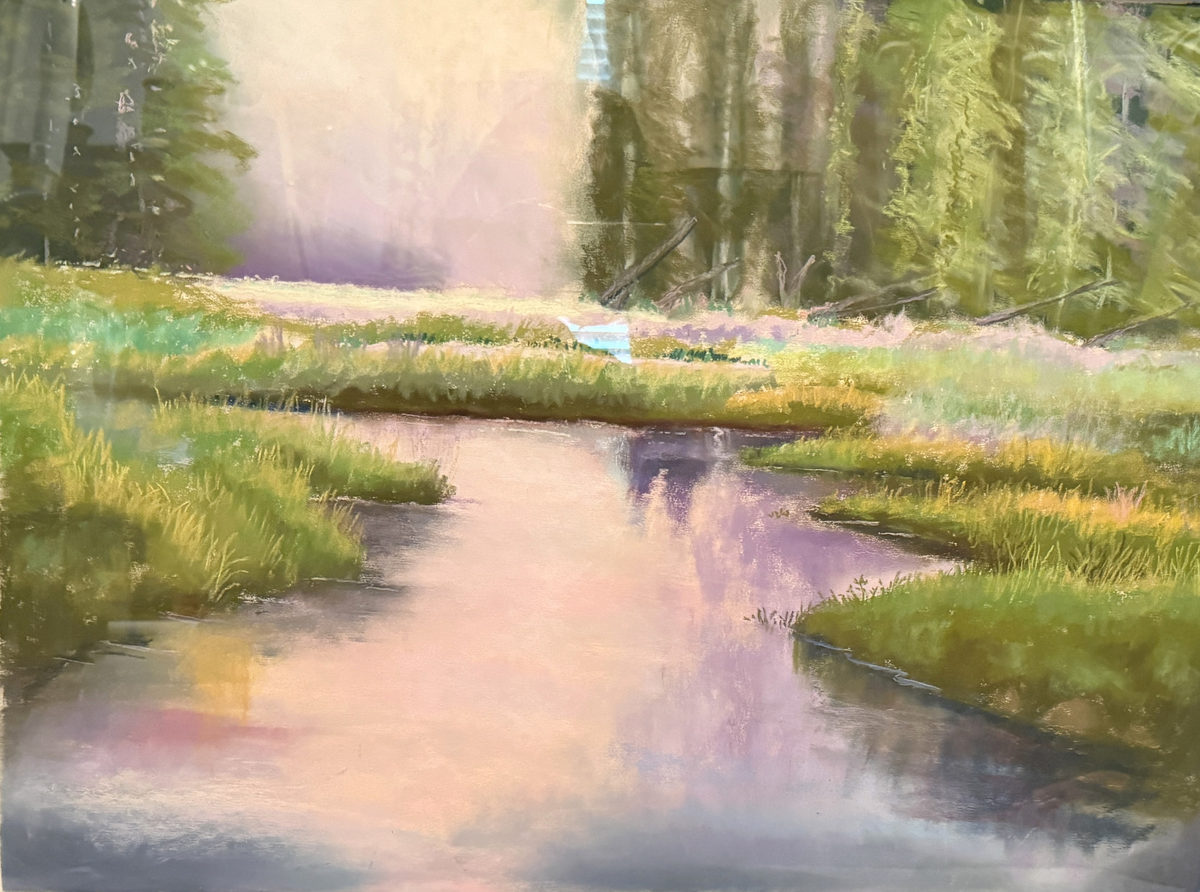 Soft pink evening light reflected through winding marsh water bordered by green grasses and dark trees